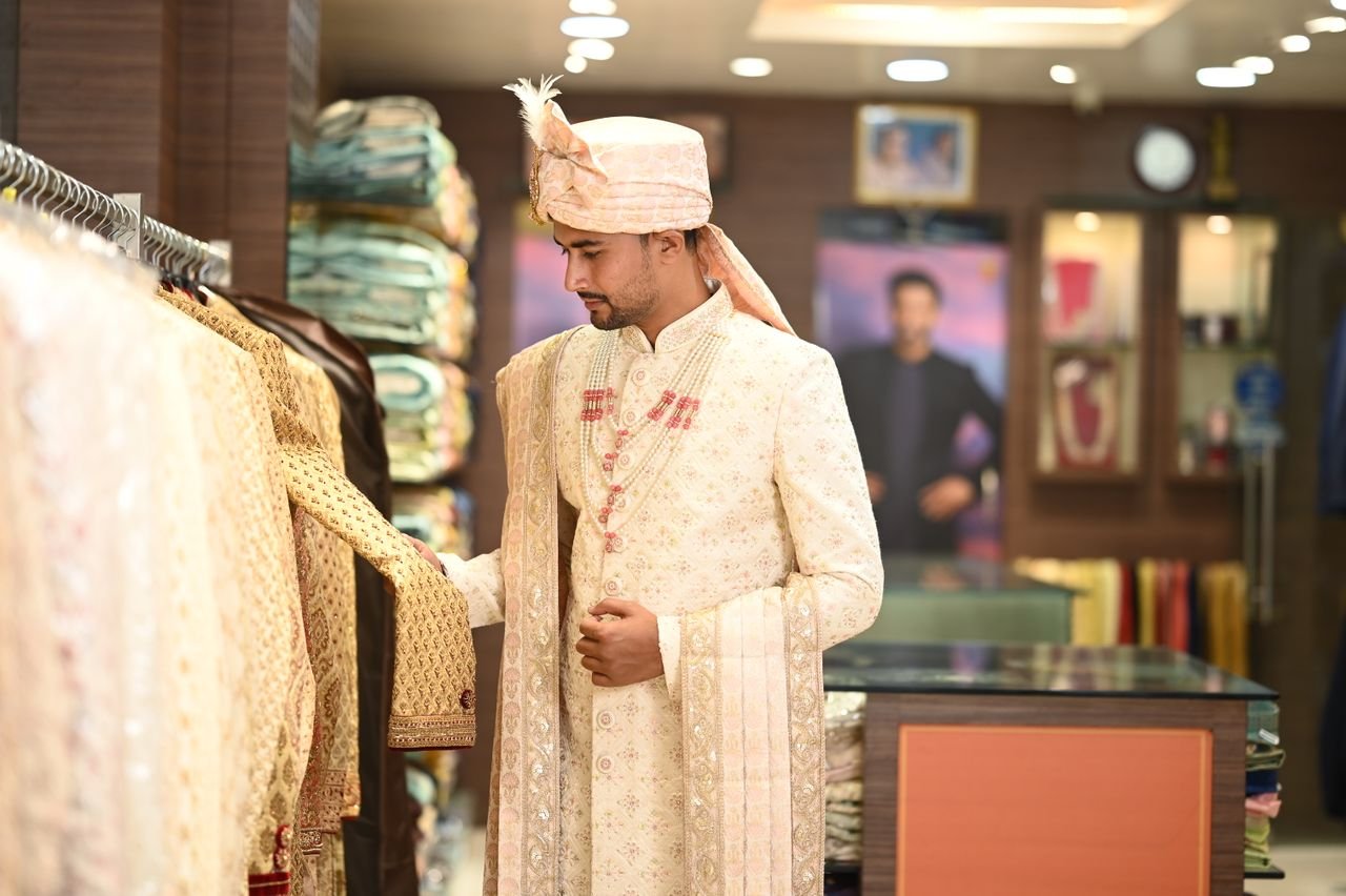 A man in traditional attire shopping in an Indian clothing store, showcasing cultural fashion.