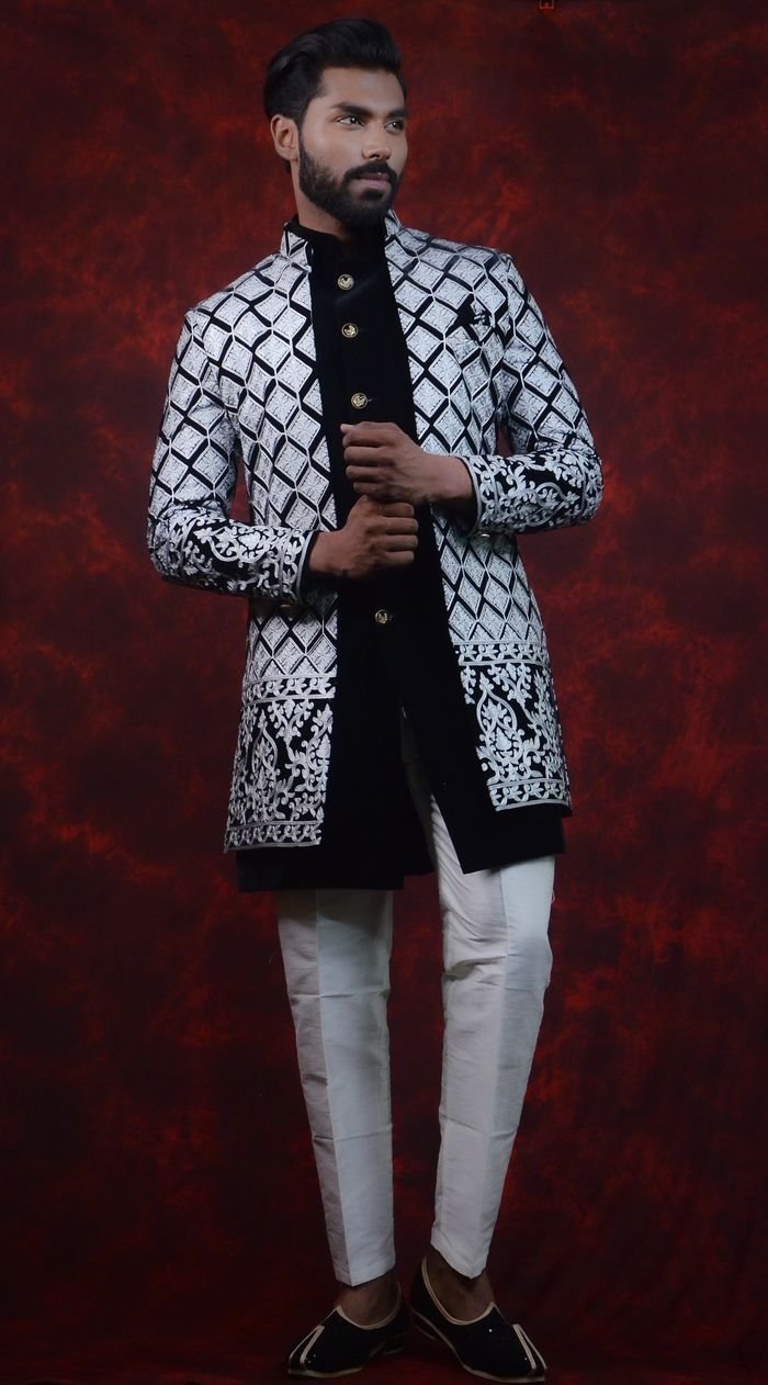 Sophisticated studio portrait of a young man in traditional Indian wear, showcasing exquisite embroidery.